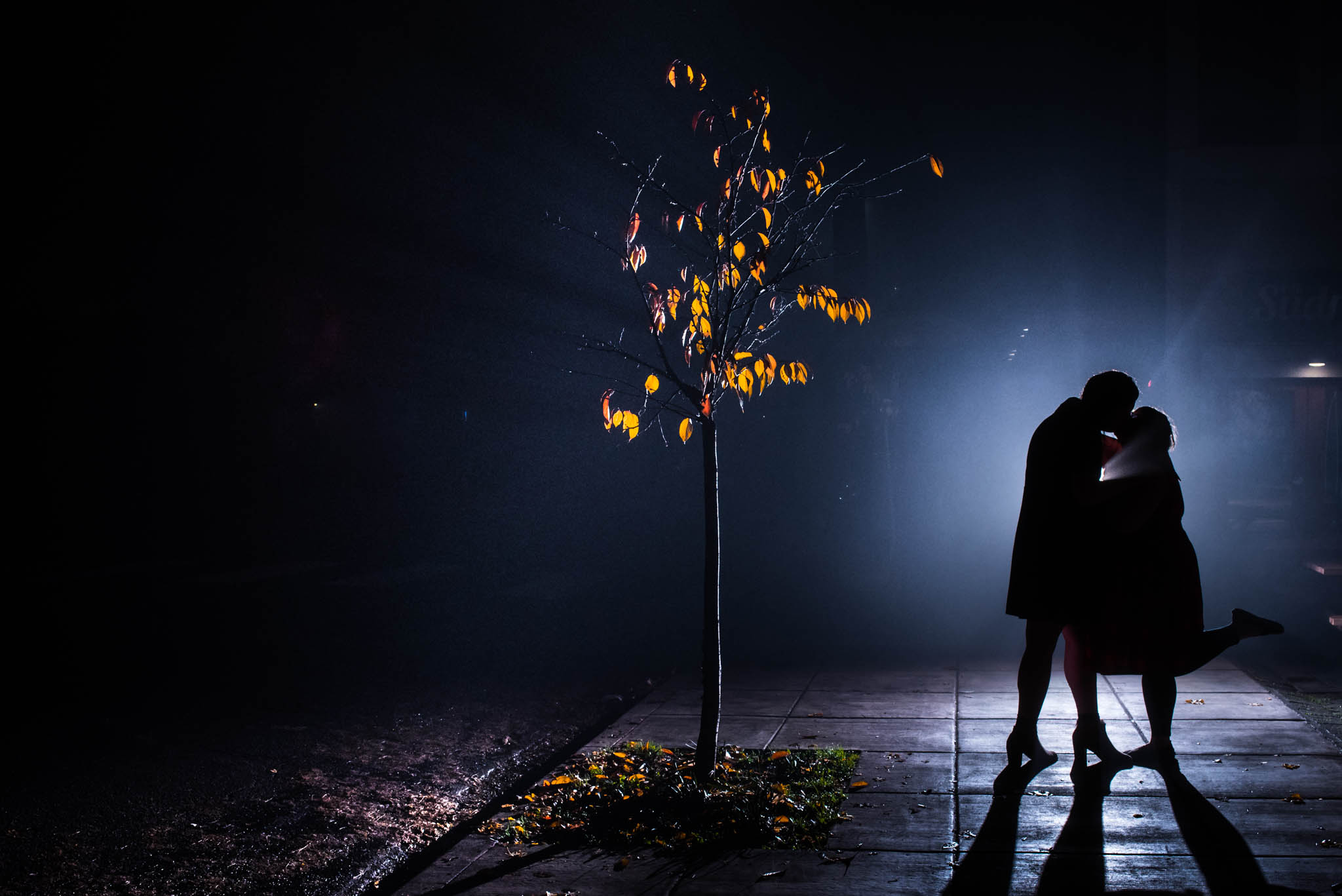 Silhouette photograph of wedding couple on misty street
