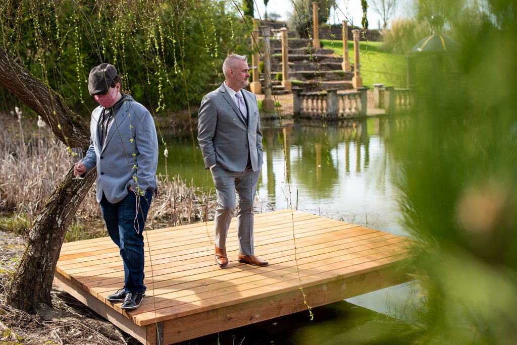 two men in suits standing on a dock.