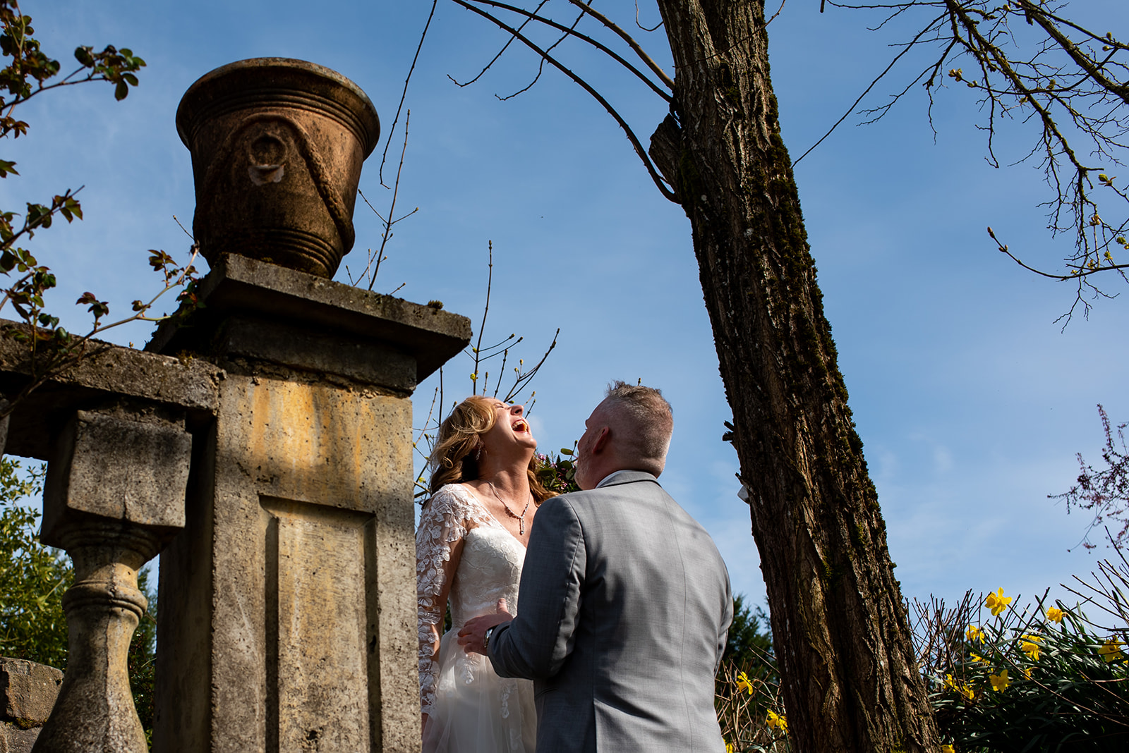 a man and a woman laughing during their first look